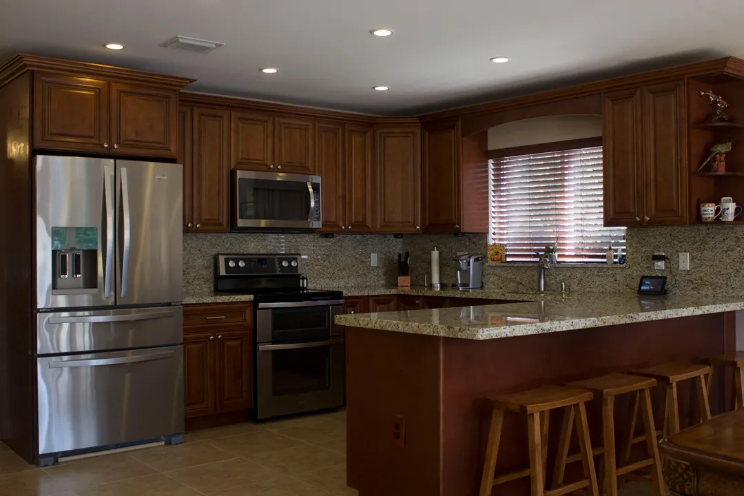 Island kitchen — wood cabinetry, granite counters, stainless appliances