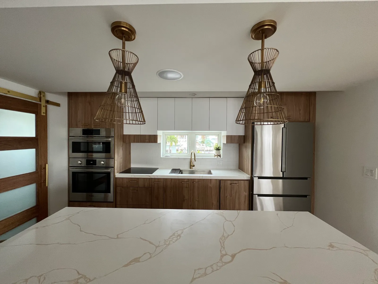 Kitchen detail — barn-door entry and matched pendant lighting