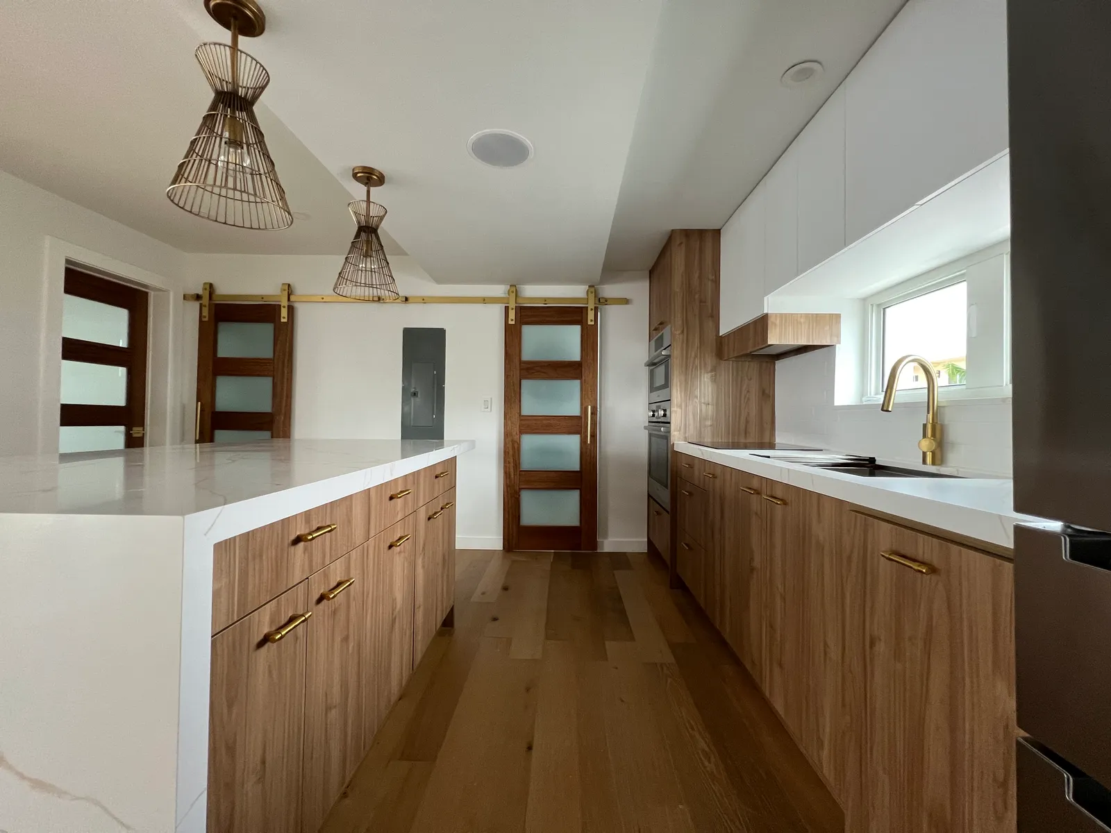 Galley kitchen — long quartz counter and stainless appliances