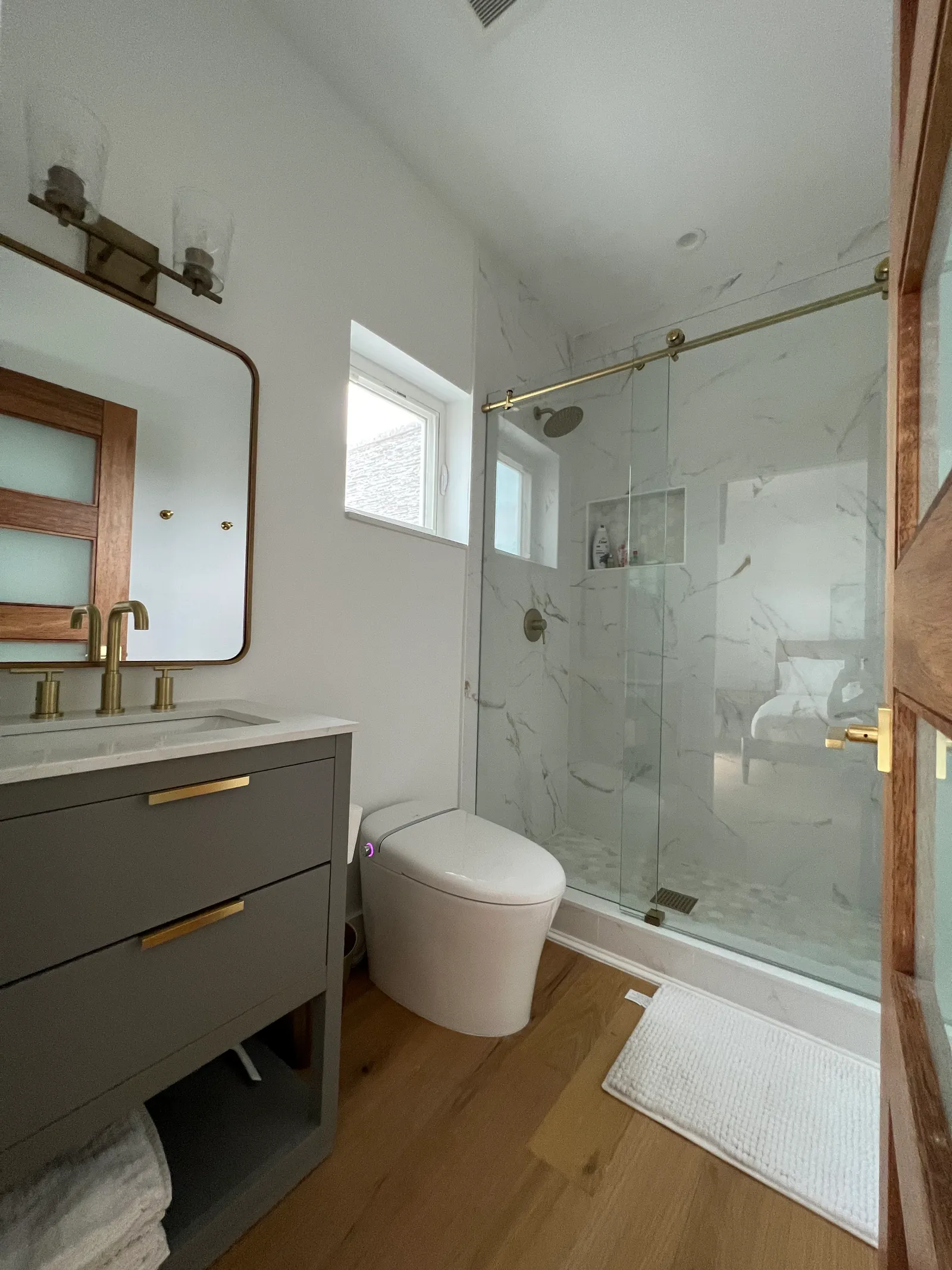 Powder bath — single vanity, glass shower, gold fixtures