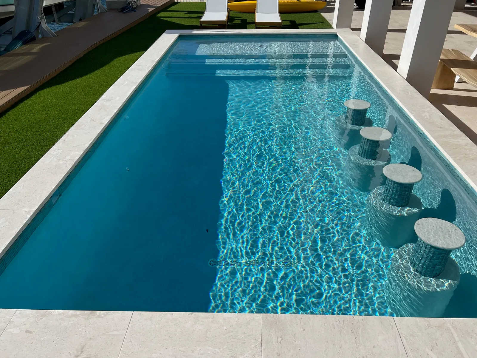 Pool with swim-up stools and shaded loungers